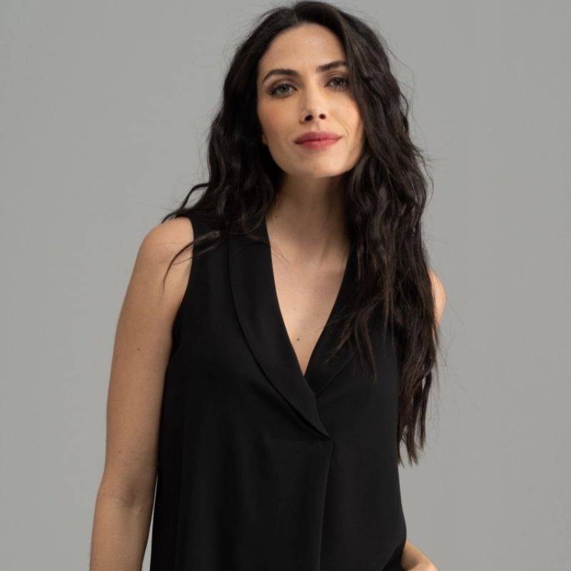 Donna che veste una camicia smanicata nera con reverse